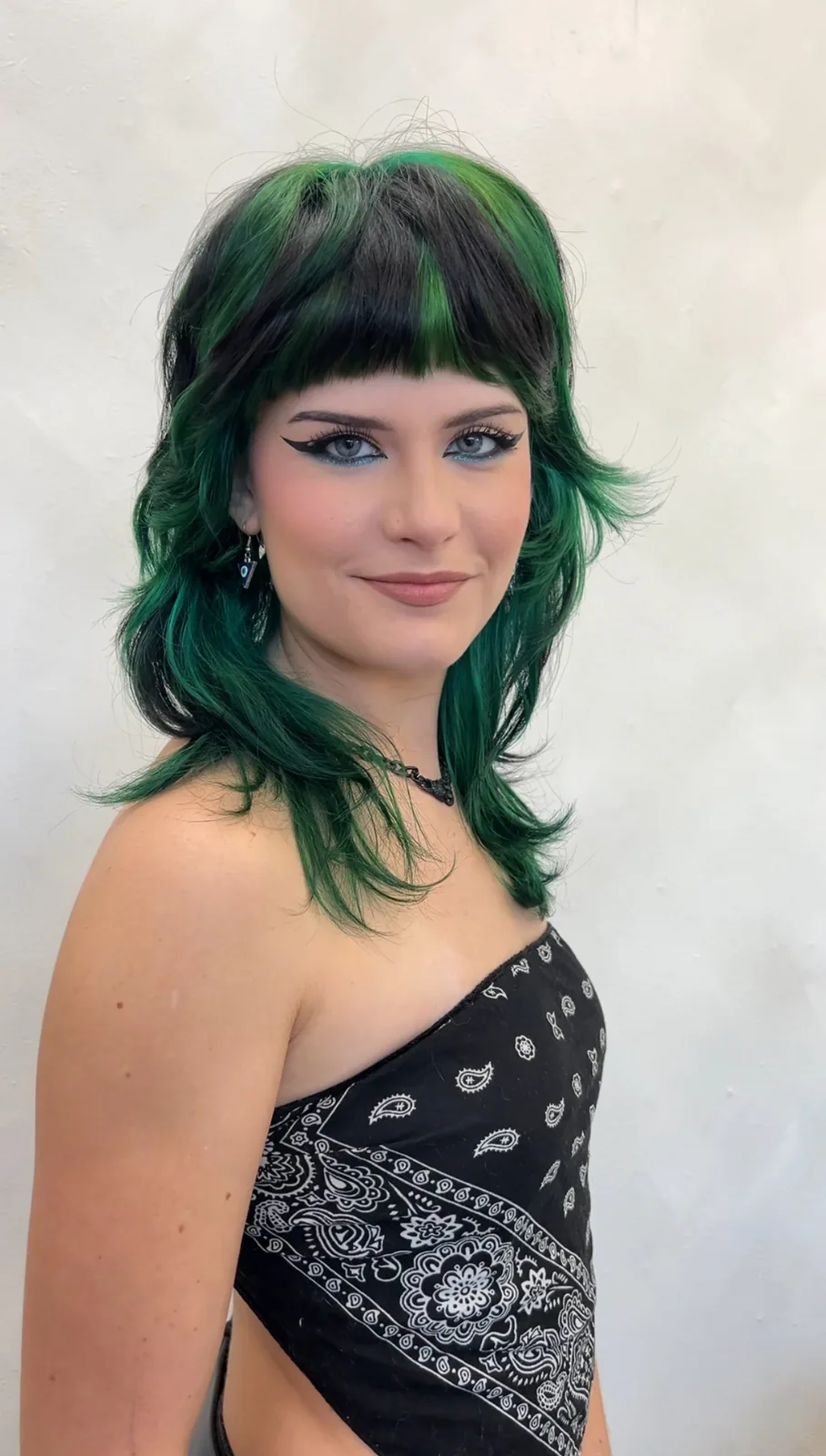 Emerald green vivid color on a modern shag cut with baby bangs — vivid color specialist at Infinite Hair Studio, Baton Rouge LA